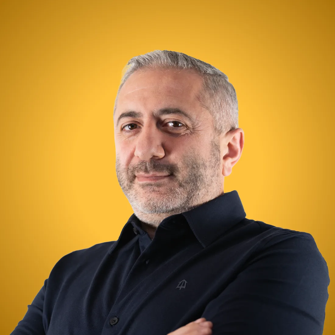 Zakelijk portret van Artak Khachatryan, oprichter en CEO van Momik, tegen een gele achtergrond