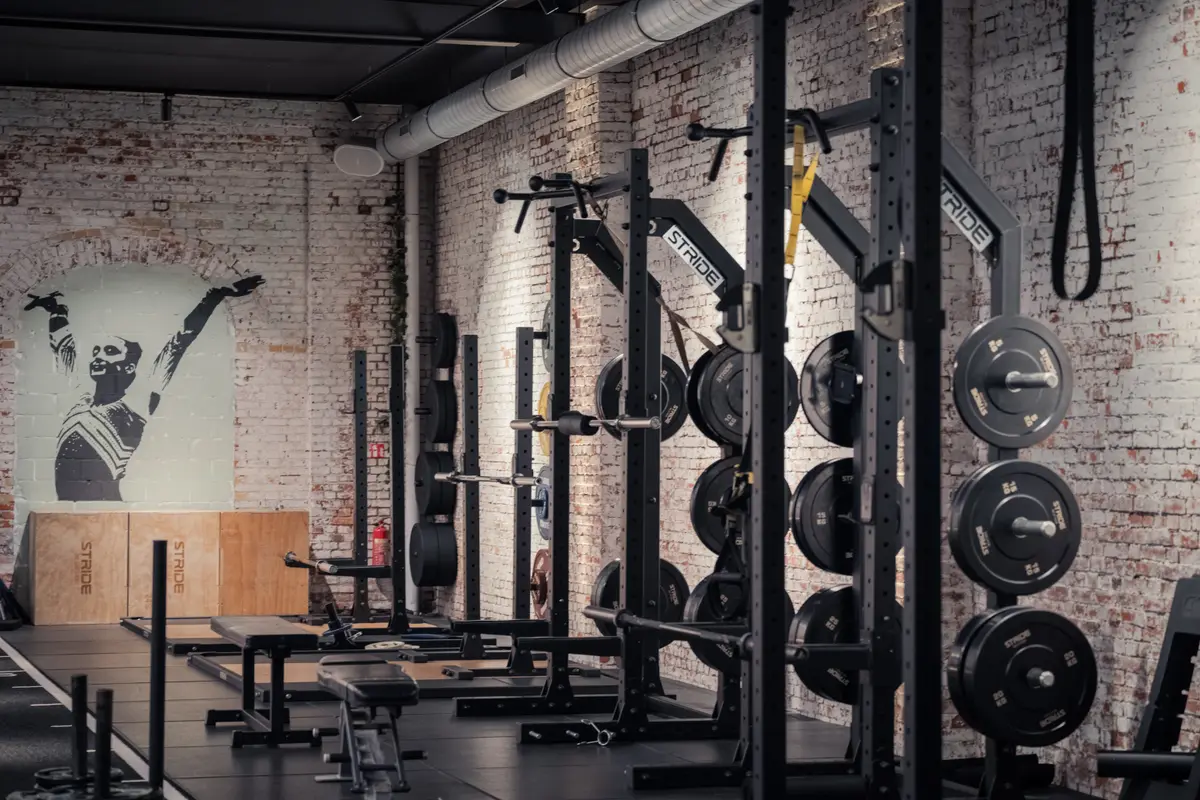 Krachtruimte bij Kineworks met STRIDE squat racks en witte brick muur