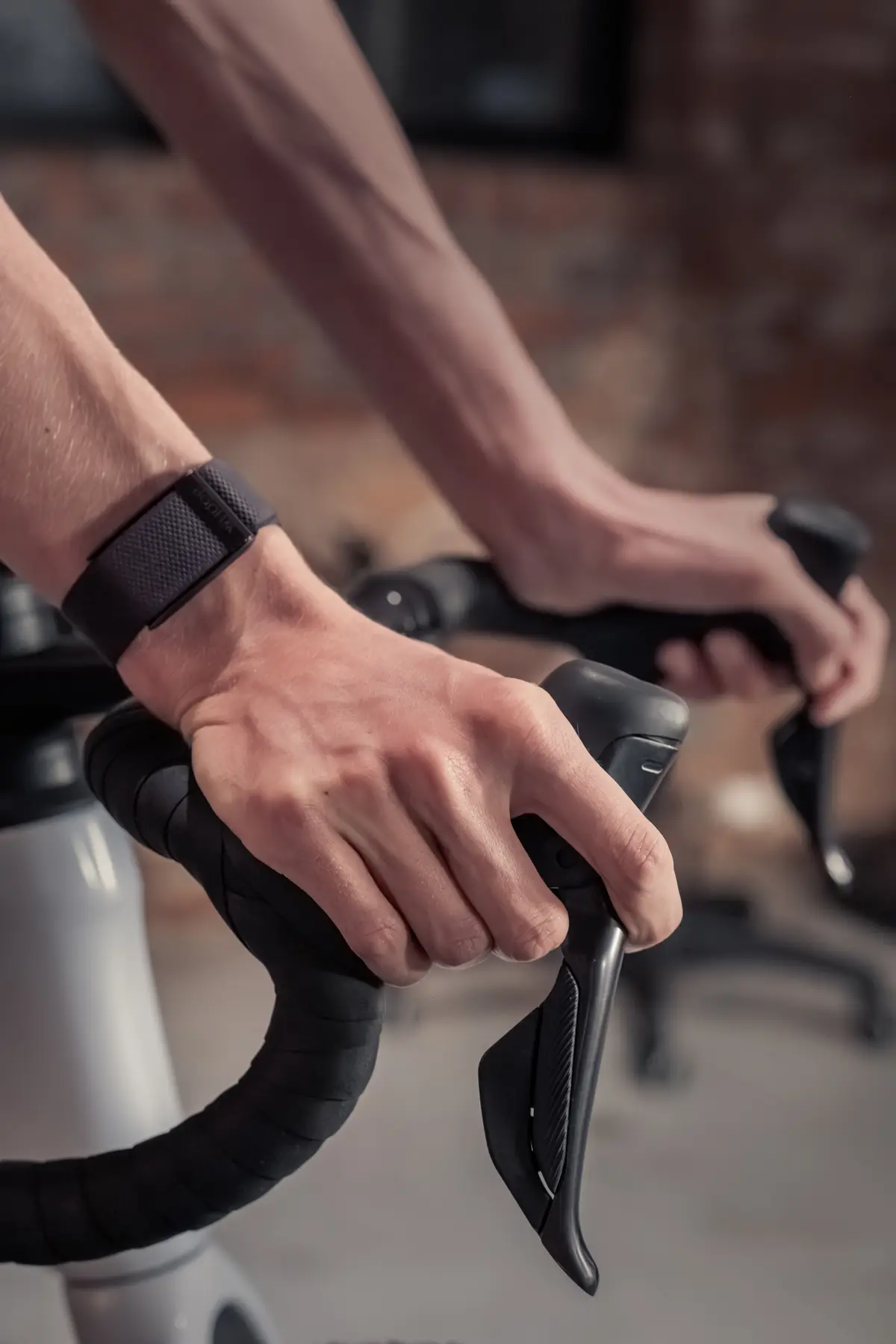 Close-up van handen op een racefiets-stuur tijdens indoor cycling bij Kineworks