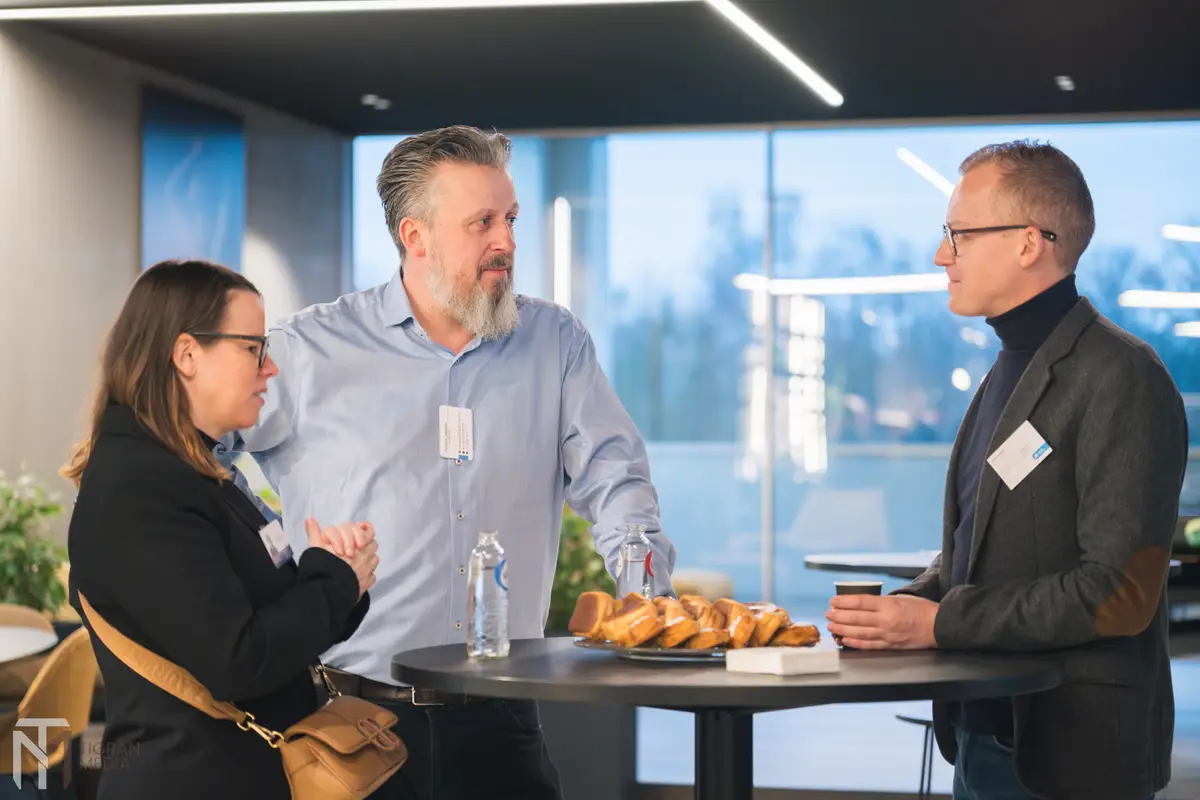 Drie ondernemers netwerken aan een statafel met koeken en koffie tijdens Open Coffee